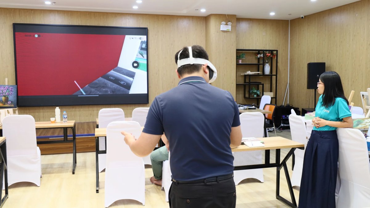 Người đeo kính VR đứng trước màn hình lớn đang chiếu hình ảnh trong kính