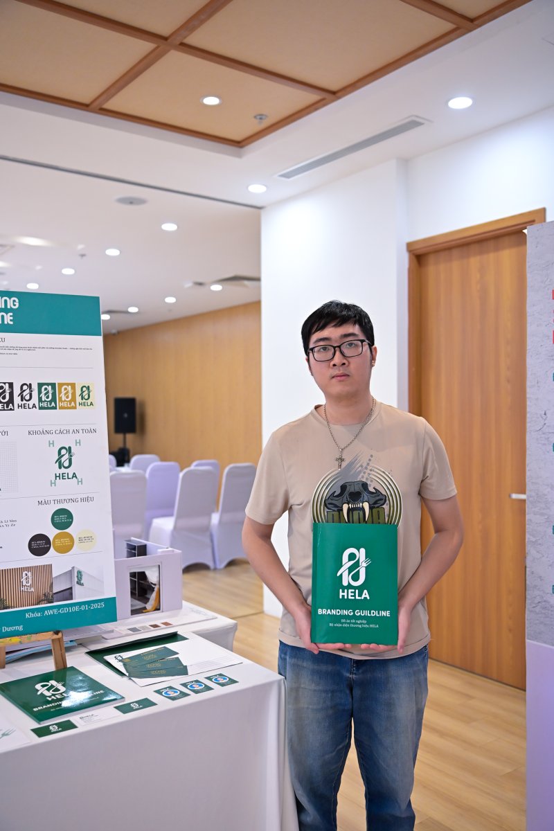 Học viên bên bàn trưng bày đồ án nhận diện thương hiệu HELA