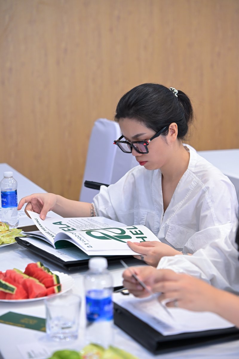 Thành viên hội đồng chấm xem cuốn brand guideline của học viên