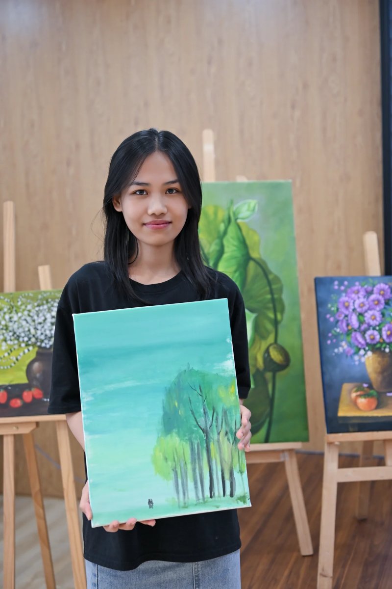 Thành viên cầm bức tranh hàng cây xanh vừa vẽ xong